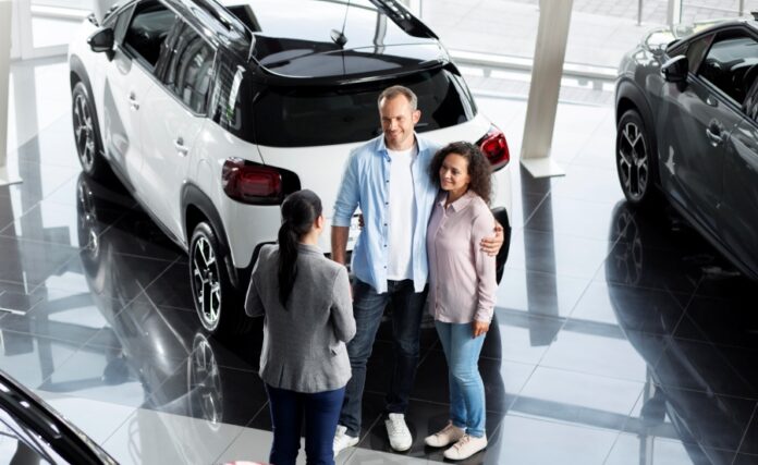 Pareja buscando en una concesionaria un auto nuevo para comprar